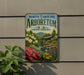 A vintage-style sign for the North Carolina Arboretum, featuring a scenic landscape with a waterfall, flowers, and a house.