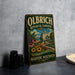 A vintage-style metal sign for Olbrich Botanical Gardens in Madison, Wisconsin, featuring a colorful illustration of the gardens and a building.