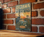 A vintage metal sign for the Ottawa National Wildlife Refuge, featuring an illustration of a crane and a sunset over a body of water.