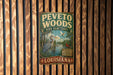 A vintage-style metal sign for the Peveto Woods Bird Sanctuary in Louisiana, featuring illustrations of birds and a natural landscape.