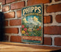 A vintage-style metal sign for the Hipps Conservatory in Pennsylvania, featuring a colorful illustration of the conservatory surrounded by tropical plants and flowers.