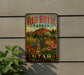 A vintage-style metal sign for the Red Butte Garden in Utah, featuring a scenic illustration of a garden with flowers, plants, and a mountain backdrop.