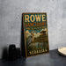 A vintage-style metal sign for the Rowe Sanctuary in Audubon, Nebraska, featuring an illustration of a bird and a wooden structure.