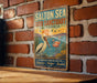 A vintage-style metal sign for the Salton Sea Bird Sanctuary in California, featuring illustrations of a pelican and flamingos.
