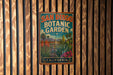 A vintage-style metal sign for the San Diego Botanic Garden in California, featuring a colorful illustration of various plants and a tropical landscape.