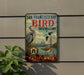A vintage-style metal sign for the San Francisco Bay Bird Observatory in California, featuring illustrations of birds, a bridge, and a city skyline.