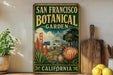 A vintage-style sign for the San Francisco Botanical Garden in California, featuring illustrations of the Golden Gate Bridge, palm trees, and various plants.