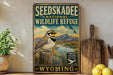 A vintage-style sign for Seedskadee National Wildlife Refuge in Wyoming, featuring a bird perched on a tree stump against a scenic landscape.