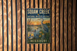 A vintage-style metal sign for Squaw Creek National Wildlife Refuge in Missouri, featuring an illustration of a bird and a serene landscape.