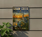A vintage-style sign for Squaw Creek National Wildlife Refuge in Missouri, featuring an illustration of a heron and a sunset over a body of water.