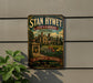 A vintage-style sign for "Stan Hywet Hall & Gardens" in Akron, Ohio, featuring an illustration of a historic building surrounded by a garden.
