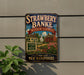 A vintage-style sign for Strawberry Banke Museum Gardens in New Hampshire, featuring a colorful illustration of a historic building surrounded by flowers.