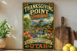 A vintage-style sign for Thanksgiving Point Gardens in Utah, featuring a garden scene with a waterfall and colorful flowers.