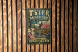 A vintage-style metal sign for the Tyler Arboretum in Pennsylvania, featuring a scenic landscape with a bridge and trees.