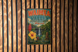 A vintage-style metal sign for Waimea Valley Botanical Garden in Hawaii, featuring a tropical landscape with a waterfall and various flora.