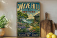 A vintage-style poster of a garden with a house and a river in the background, displayed on a wall next to a wooden cutting board and some potted plants.