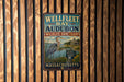 A vintage metal sign for Wellfleet Bay Audubon Wildlife Sanctuary in Massachusetts, featuring an illustration of a heron and a house.