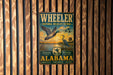 A vintage metal sign for the Wheeler National Wildlife Refuge in Alabama, featuring a bird illustration and text promoting habitat tours, wildlife viewing, and conservation.