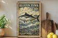 A vintage-style stamp featuring a bluefin tuna fish, with the text "BLUEFIN TUNA 10¢" and "THUNNUS THYNNUS" printed on it. The stamp is displayed on a wall, with a wooden cutting board and a potted plant visible in the foreground.
