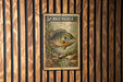 A 5¢ postage stamp featuring a bluegill fish is displayed on a wooden wall.