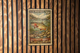 A U.S. postage stamp featuring a cutthroat trout, which is a type of fish, is displayed on a wooden wall.