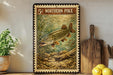 A framed print of a fish, likely a pike, is displayed on a wall next to a wooden cutting board and some lemons.