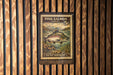 A metal sign with a colorful illustration of a pink salmon, mounted on a wooden wall.