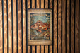 A vintage-style postage stamp featuring a large, colorful fish, likely a Rockfish, on a wooden background.