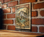 A vintage-style postage stamp featuring a striped fish, mounted on a brick wall.