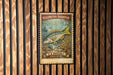 A vintage U.S. postage stamp featuring a yellowtail snapper fish, mounted on a wooden wall.