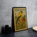 A vintage American Goldfinch postage stamp is displayed on a table, featuring a yellow bird perched on a branch with a flower.