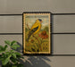 A postage stamp featuring an American Goldfinch perched on a branch with a flower, mounted on a wall next to a plant.