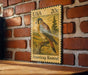 A 20c US postage stamp featuring an illustration of an American Kestrel bird perched on a branch.