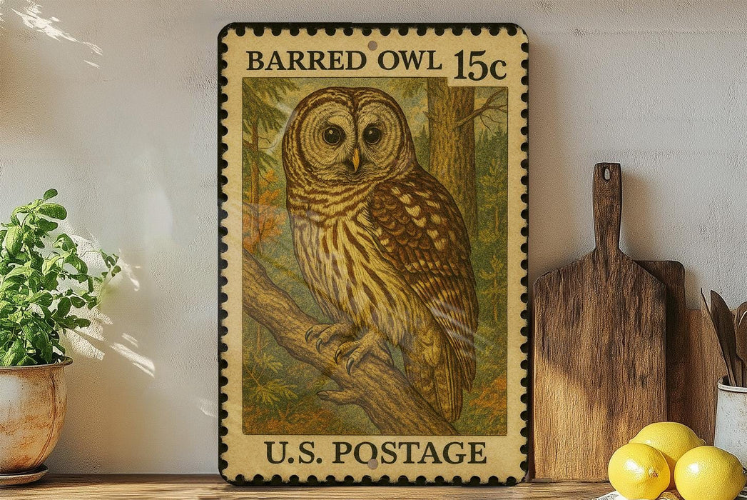 A vintage postage stamp featuring an illustration of a barred owl, with the text "BARRED Owl 15c" and "U.S. POSTAGE" printed on it. The stamp is displayed on a shelf next to a wooden cutting board and a potted plant.