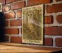 A vintage-style postage stamp featuring an illustration of a barred owl is displayed on a brick wall.