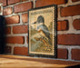 A vintage-style postage stamp featuring a colorful illustration of a kingfisher bird, mounted on a brick wall.