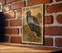 A vintage postage stamp featuring a black vulture is displayed on a brick wall.