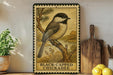 A framed illustration of a black-capped chickadee perched on a branch, with the text "BLACK-CAPPED CHICKADEE" below the image.
