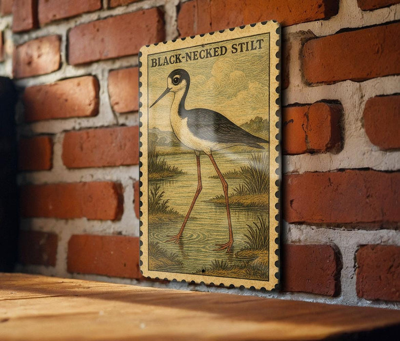 a vintage-style stamp or postcard with a black-necked stilt illustration on a brick wall.