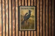 A U.S. postage stamp featuring a black and white bird perched on a grassy field, with the text "BOBOLINK 10¢ U.S. POSTAGE" printed on it.