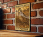 A vintage-style postage stamp featuring a quail bird is displayed on a brick wall.