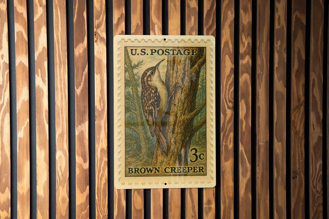 A U.S. postage stamp featuring a brown creeper bird perched on a tree.