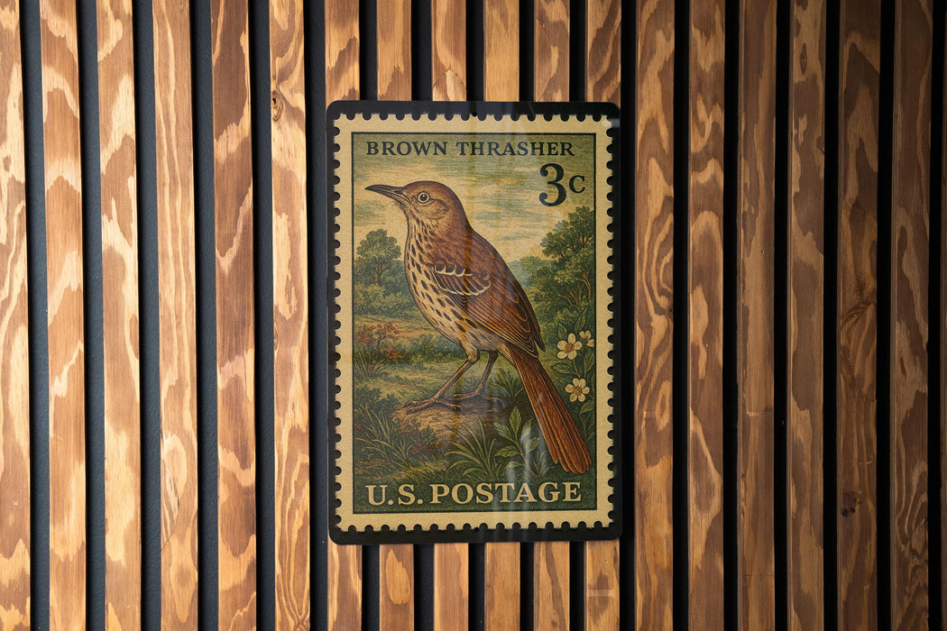 A vintage brown thrasher postage stamp from the U.S. Postal Service, featuring a detailed illustration of a bird perched on a branch.