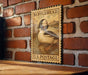 A vintage-style postage stamp featuring a duck on a brick wall, with the text "BUFFLEHEAD U.S. POSTAGE" printed on it.