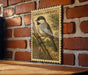 A vintage postage stamp featuring a Carolina Chickadee perched on a branch, mounted on a brick wall.