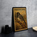 a framed illustration of a bird, specifically a dark-eyed junco, perched on a branch.