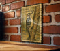 a vintage-style stamp or postcard with a woodpecker illustration, mounted on a brick wall.