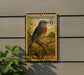 A vintage-style postage stamp featuring a bluebird, mounted on a wall next to a plant.