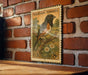 A vintage Eastern Towhee postage stamp is displayed on a brick wall, featuring a colorful illustration of a bird perched on a branch with flowers.
