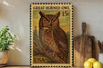 A framed stamp depicting a Great Horned Owl, a type of owl, is displayed on a shelf next to a wooden cutting board and some lemons.